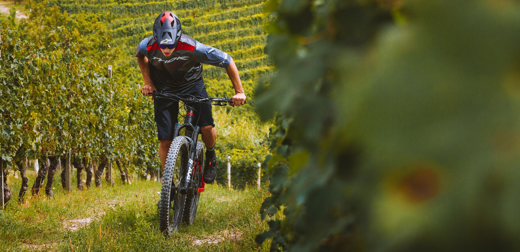 The grey and red MIG-R by Thok Ebikes, on a stunning landscape mixing sea and mountain. 